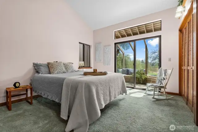 Primary bedroom with doors to the sunroom/hot tub