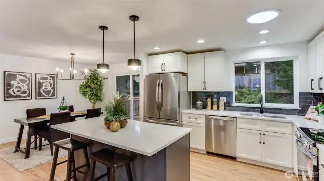 Beautifully remodeled all new kitchen with sleek cabinets, island with breakfast bar seating complimenting the backsplash, new light fixtures, quartz counters and all new stainless steel appliances.