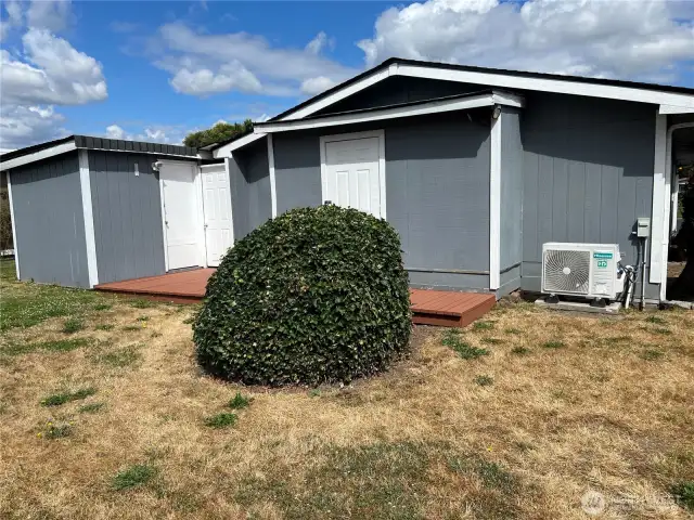 View of the back of the house with storage areas and deck.