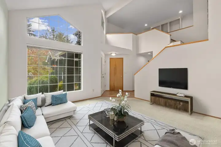 BRIGHT AND INVITING LIVING ROOM HAS PLENTY OF SPACE FOR FURNITURE, AND ABUNDANT NATURAL LIGHT.
