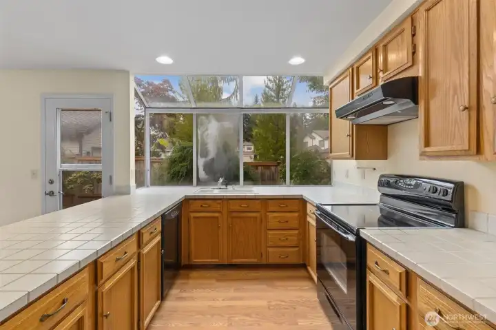 CHARMING KITCHEN W/ ATRIUM WINDOW & SERVING BAR.