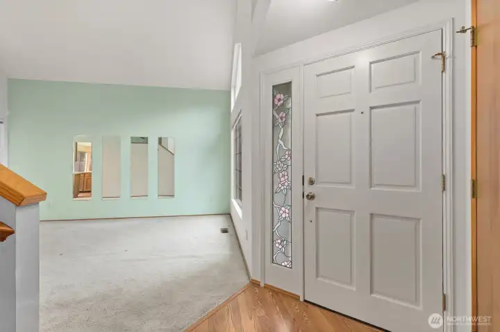 WELCOMING FOYER, WITH VAULTED CEILINGS AND EASY ACCESS UPSTAIRS.