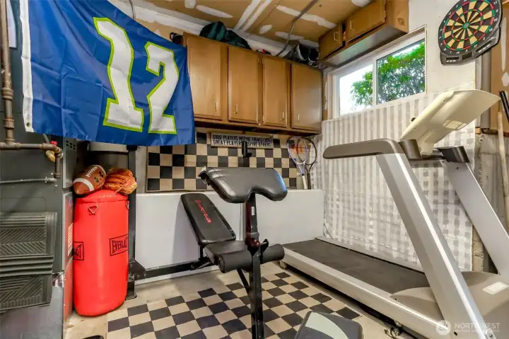 There is an approximate 5x5 shop space adjacent to the garage with a window and upper cabinets that has been converted to use as a small gym.  The ceiling is sheetrocked and could use some new paint for the garage ceiling.