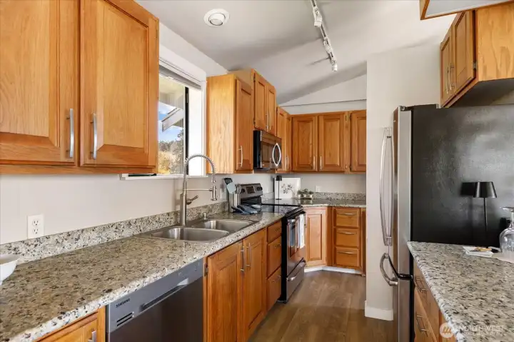 This efficient kitchen has had appliance, granite countertops, and hardware upgrades.