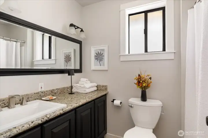 Proceeding down the hallway, first door on the right is the second bathroom - full tub/shower and updated cabinets, counters, mirror and lighting.
