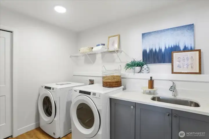Upstairs laundry room with linen closet and sink