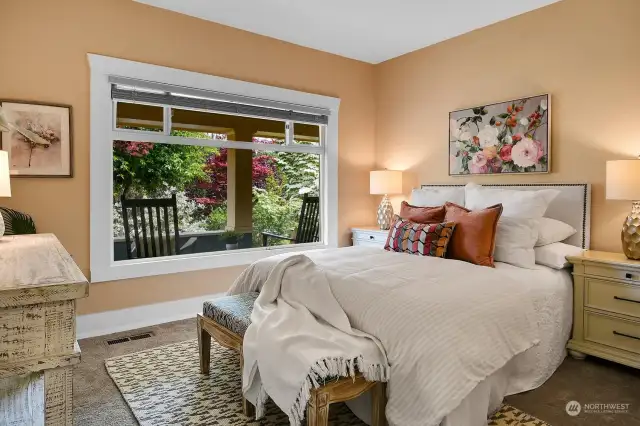 Large bedroom on main level looks onto lush grounds through large picture window. Serene!