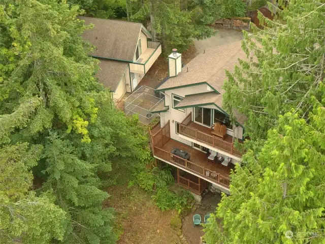 Main home an guest house together with driveway and firewood storage running along the property line at the top of the photo. Lake Cushman Rd N (Hwy 119) to the left, Lake Cushman to the right and below. .46 acres total.