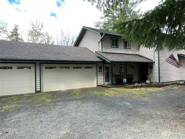 Nestled in the woods with guest house to the right, boat or RV parking to the left of the 3 car garage. Lots of covered and uncovered parking for guests.