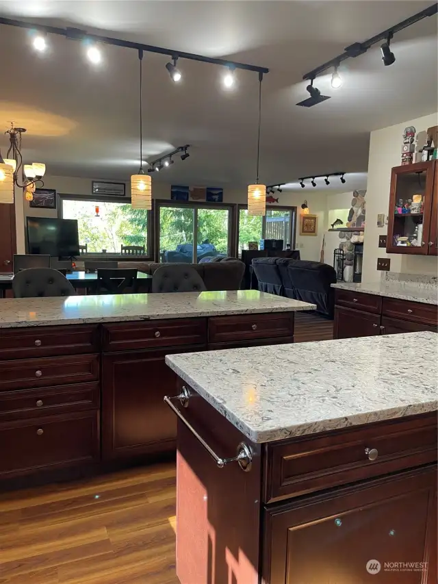 Idyllic prep island overlooking the eating bar and buffet counter. Blue-gray quartz counters wrap around the kitchen providing massive counterspace for the meal preparation.