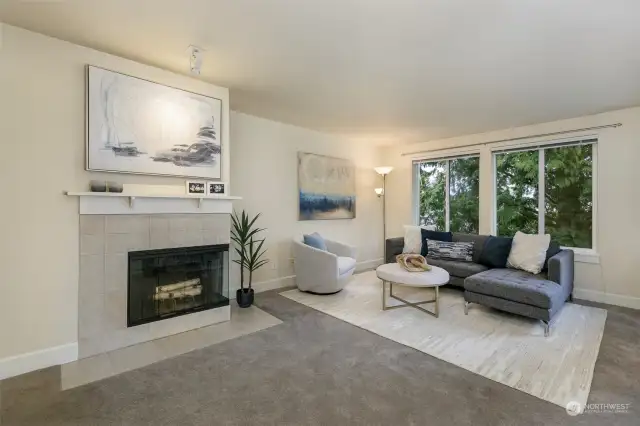 Spacious light-filled living room features wood-burning fireplace.