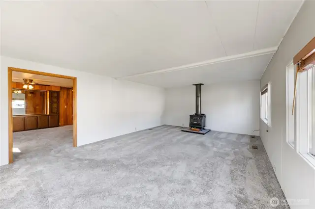 Large living area w/ free standing wood stove & also newer carpeting
