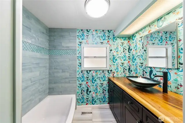 Main full bath w/ marble floor, newer tub w/ tile surround, decorative sink also.