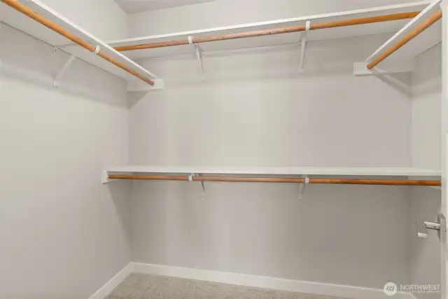 Primary bed walk- in closet. Solid shelving in all closets. Photos of a similar home, not actual, for illustration only.
