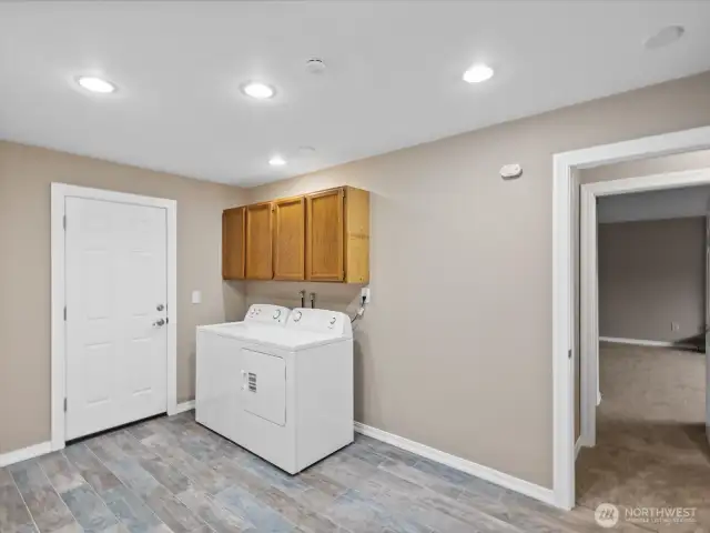 Lower level refurbished laundry room leads to back yard and garage.