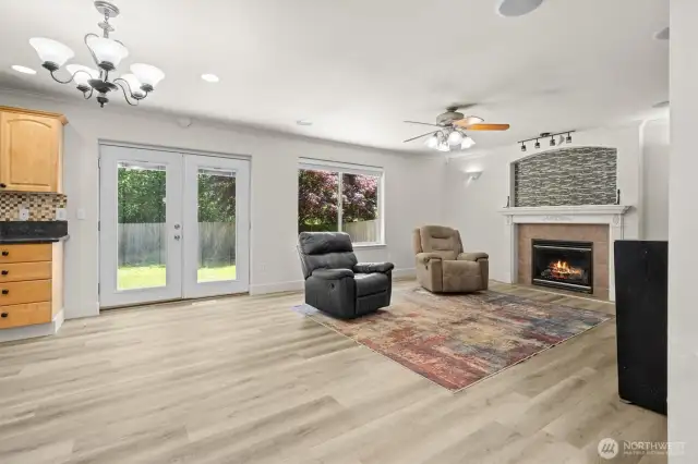 The kitchen opens up to a second dining and living space featuring a cozy gas fireplace