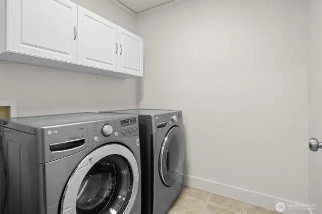 Spacious laundry room with built-in cupboards for storage
