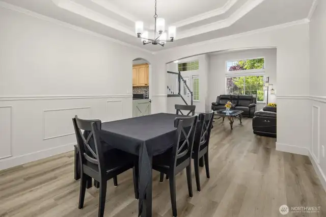 Formal dining room with ornate tray ceiling and chair-rail molding