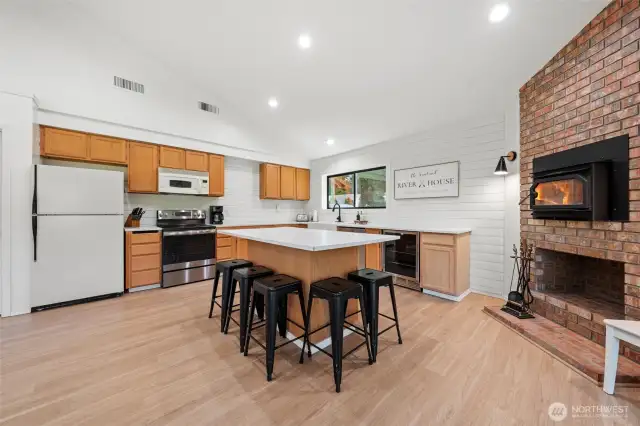 The exposed brick hearth and wood-burning fireplace bring rustic elegance and inviting warmth to this heart-of-home kitchen