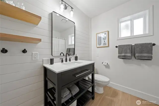 Step into luxury with a modern farmhouse bathroom featuring clean lines, a wood vanity, designer lighting