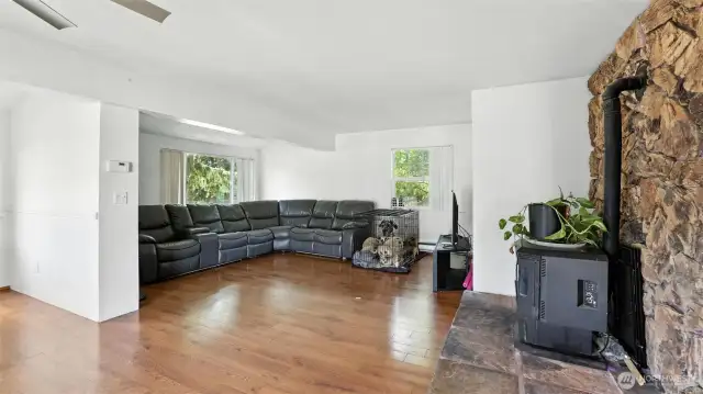 The wood stove and bright white walls create a bright yet cozy vibe in this living room.