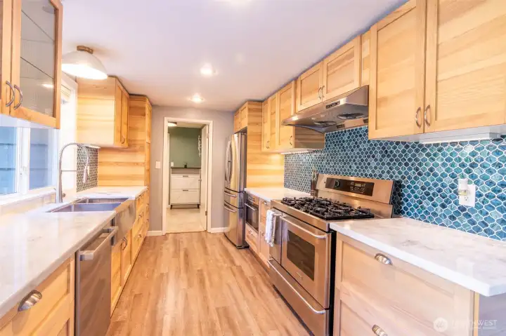 Newly updated chef’s kitchen boasts marble counters, custom backsplash, soft-close cabinetry, 40” pro dual oven/5-burner range, built-in microwave & 33” sink.