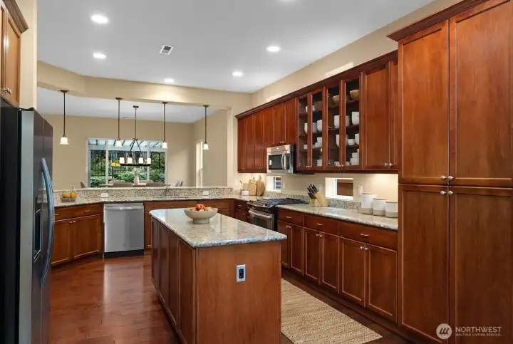 Spacious kitchen featuring a gas range, upgraded 42" cabinets, pull-out pantry shelves, upper and lower recipe windows, and a large eat-in flex space just off the kitchen.