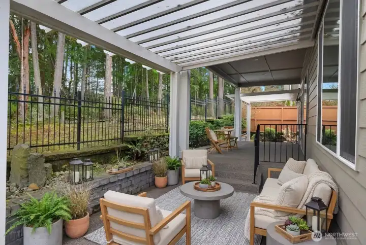 rivate backyard with three covered patios, Leaf Guard gutters, drip system, water feature, and fully fenced, all surrounded by wooded privacy and beautiful nature views.