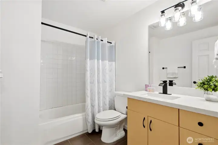 Second bathroom featuring updated countertop and modern lighting.