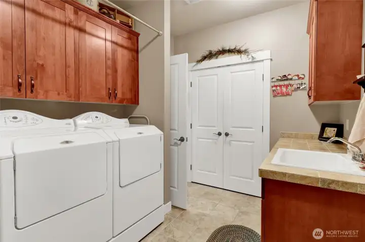 Spacious laundry room with storage and utility sink.