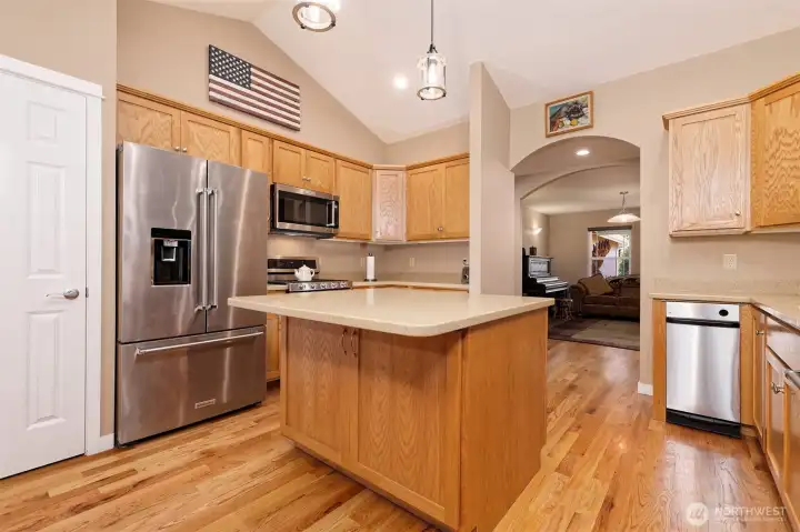 Kitchen with hardwood floor and island with stainless appliances.