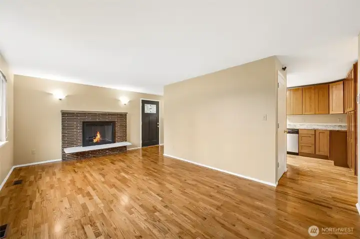 Charming living area with a beautifully updated fireplace surround, natural light, and warm wood flooring—perfect for relaxing or entertaining.