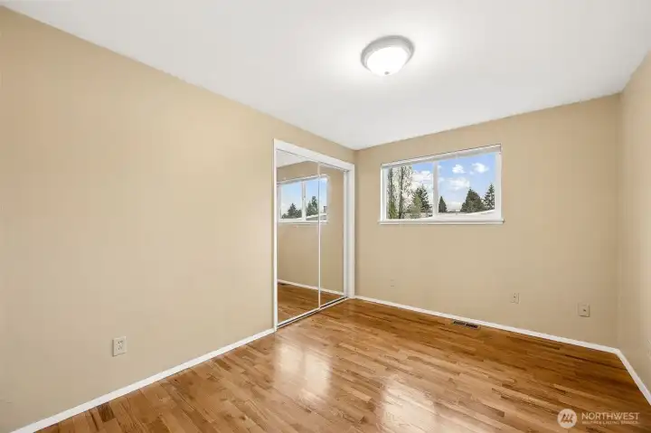 Bright secondary bedroom with hardwood floors and a clean, updated aesthetic—ideal for guests, office use, or a nursery