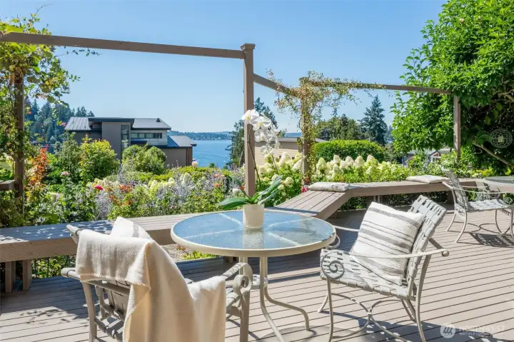 The full sweep of Lake Washington framed by the Ohashi-designed perennial garden, blooming hydrangeas, lavender, and a climbing pergola overhead. Built-in bench seating wraps the deck's edge, making this outdoor room as functional as it is breathtaking.