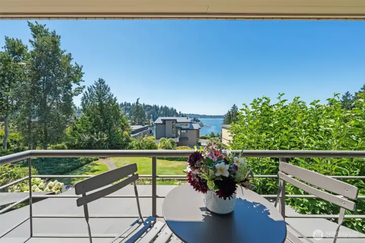 The private primary suite balcony frames an unobstructed Lake Washington view over the Ohashi-designed community lawn and perennial garden below. A steel-railed outdoor perch perfectly scaled for two — where the water, the sky, and the silence are all yours.