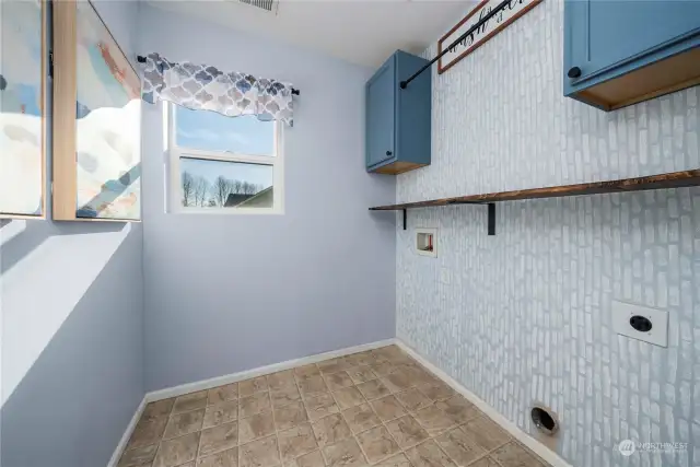 Upstairs laundry room with storage and hanging rack