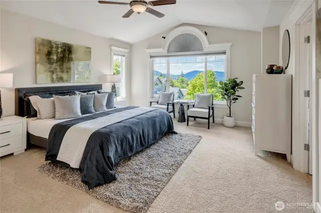 The spacious primary bedroom feels even larger with its vaulted ceilings and abundant natural light. West-facing windows frame stunning mountain views and vibrant sunsets