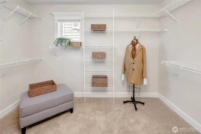 The spacious primary closet offers ample storage with built-in organization, providing a functional and tidy space for wardrobes of all sizes.