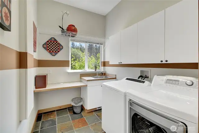 Large laundry room with utility sink and fold out ironing board.
