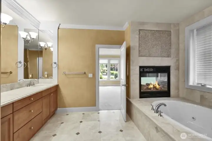 Cozy double-sided gas fireplace in the primary bathroom.