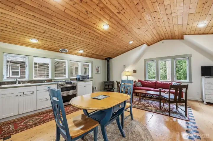 Bright open floor plan with beautiful wood detail and a cozy woodstove in the corner.