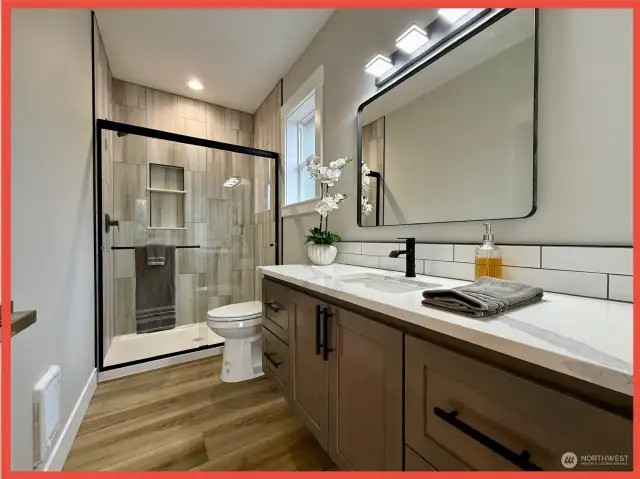 Private bathroom with custom tiled walk-in shower.