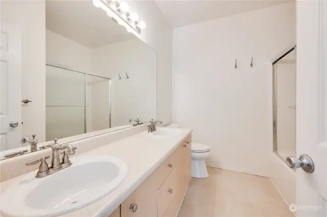 Primary bathroom with a dual sink vanity with lots of counter space and tub/shower combo.
