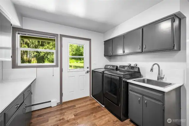 The spacious laundry room features convenient backyard access, seamlessly connecting to a dedicated dog run area—perfect for pet owners seeking functionality and ease.