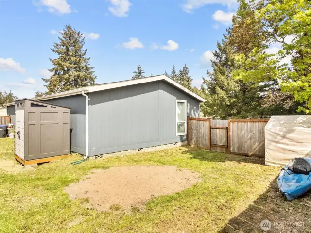 At the back of the home is a fence and gate separating the garden area.