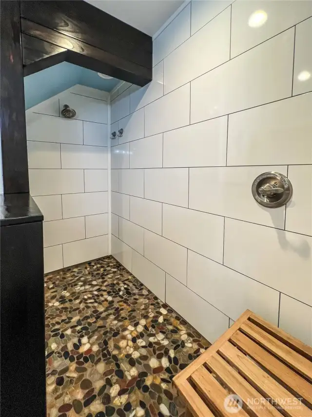 Custom oversized walk-in shower with river rock floor
