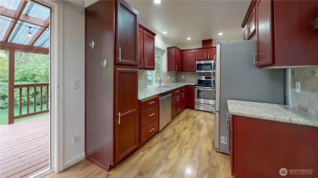 Kitchen offers granite counters, ample cabinetry, and laminate flooring