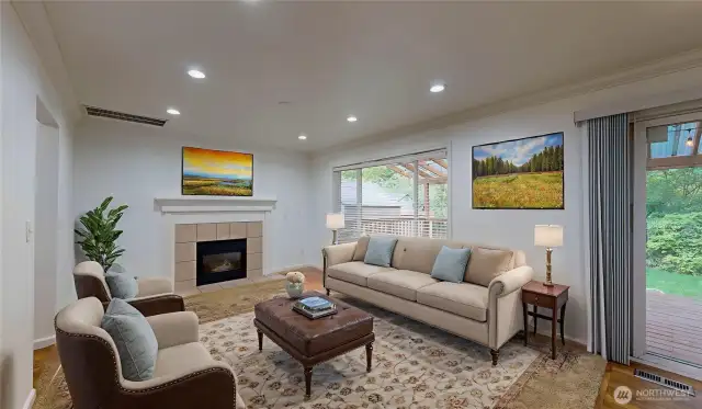 Cozy Family Room offers a warm and comfortable atmosphere with a gas fireplace with a large window bring in natural light and provide serene views of the lush greenbelt