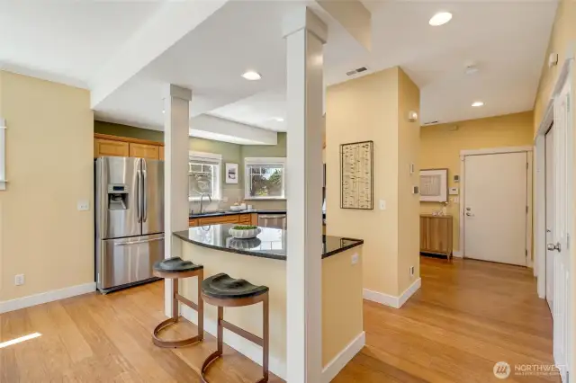Open walkway to entry and kitchen, highlighting the fluid floor plan and easy navigation throughout the home.
