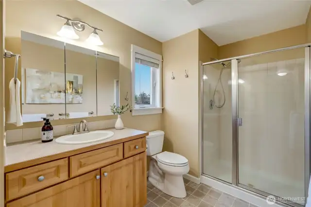 Additional photo of primary bathroom with clean finishes and storage—perfect setup for shared use.